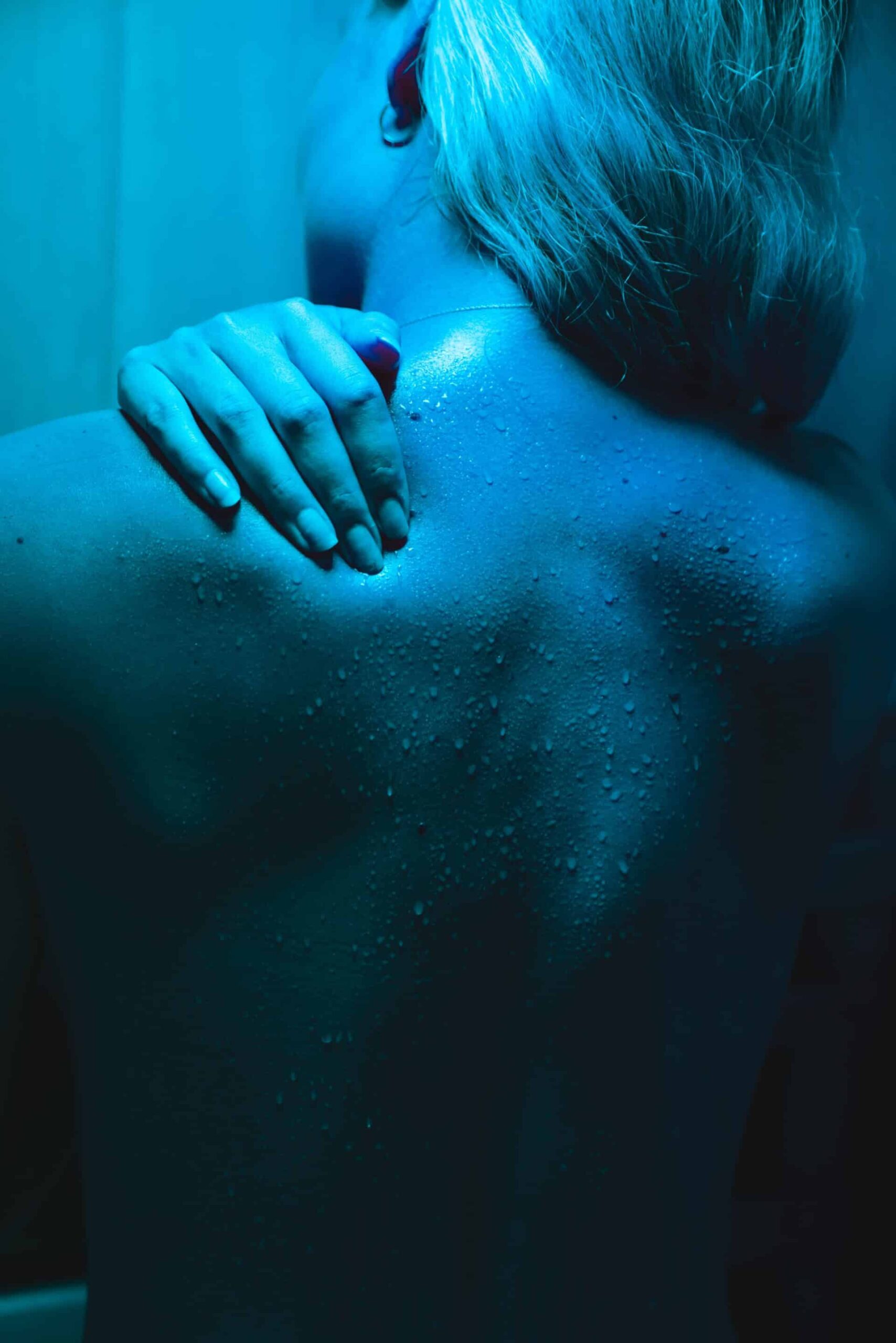A hand touching someone's upper back with back pain.