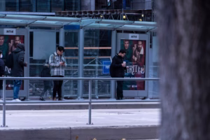 Man having poor neck posture while waiting for transit in Toronto, may lead to neck pain